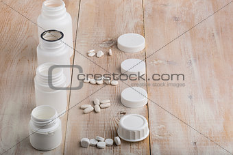 Various white plastic pill bottles and heap of drugs