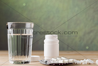 Glass of clean water and pill blister packs