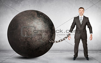 Businessman chained to large ball