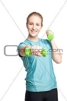 Athletic young woman works out with green dumbbells