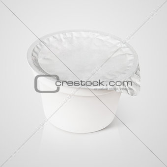 White plastic container with foil lid on gray