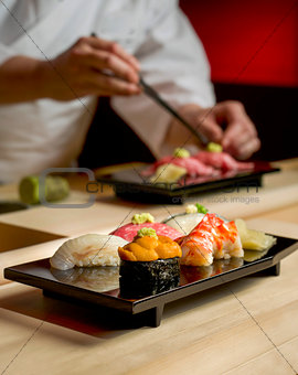 Assorted Sushi with Chef as background