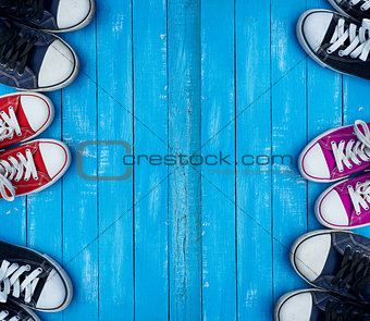 Youth colored sneakers on a blue background of the wooden planks
