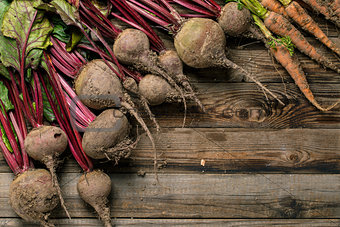 Young beets and carrots on wooden table