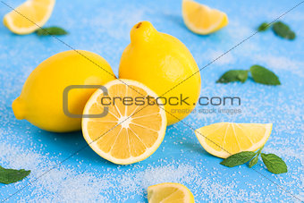 Lemon on the blue wood table with mint and sugar