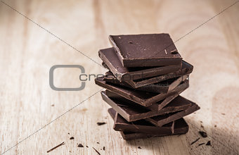 Chocolate Bars Stack on Wooden Table.