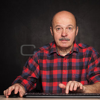 man in a white shirt works at the computer, typing text
