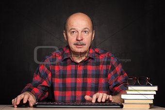 man in a white shirt works at the computer, typing text