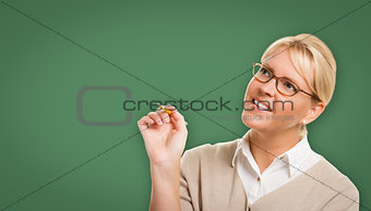 Attractive Young Woman with Pencil In Front of Blank Chalk Board