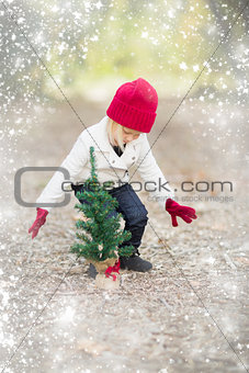 Girl In Red Mittens and Cap Near Small Christmas Tree with Snow 