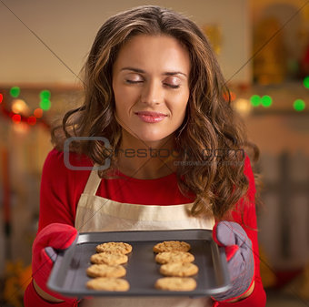 Young housewife enjoying pan of fresh cookies