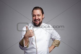 Pleased chef laughs and shows thumbs up.