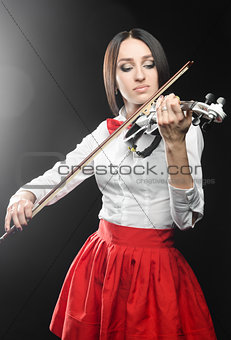 Beautiful woman playing the violin on a black background 