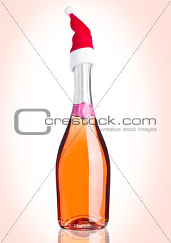 Bottle of pink rose champagne with santa hat pink