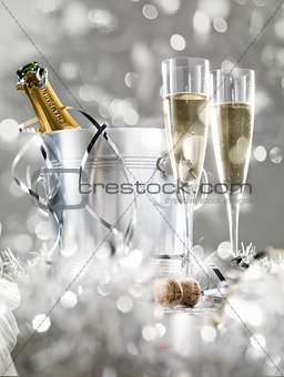 Two champagne glasses, a cooler with cork and silver decoration,