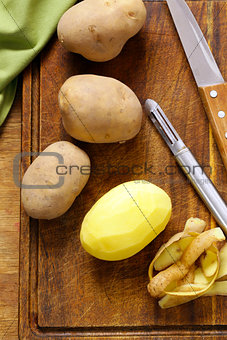 Peeled and sliced raw potatoes on a cutting board