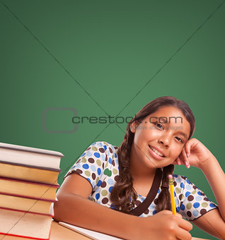 Cute Hispanic Girl StudyingIn Front of Blank Chalk Board