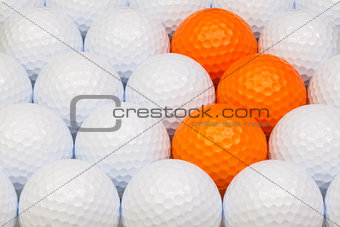 White and orange golf balls in the box