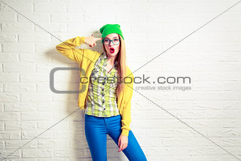 Fashion Hipster Girl at White Brick Wall