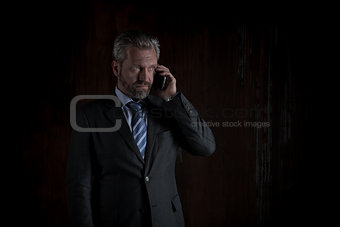 Portrait of a mature businessman on black background