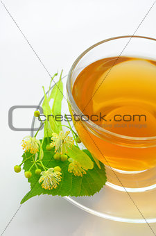 cup with linden tea and flowers