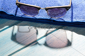 stylish sunglasses and towel on table