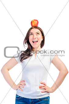 Funny girl with apple on her head on a white background