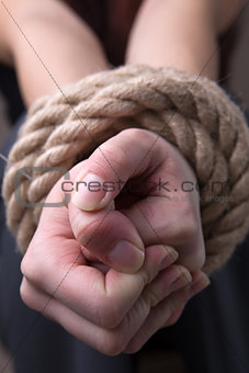 Tied rope hands of woman