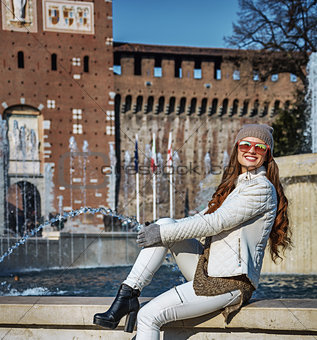 tourist woman in front of Sforza Castle sitting near fountain