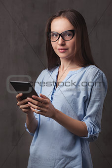 portrait of beautiful happy young woman with glasses reading eBook