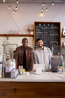 Business partners at the counter of a coffee shop, vertical