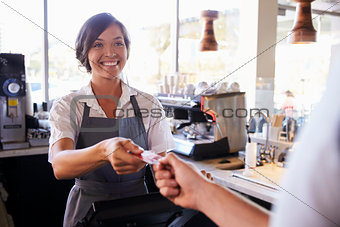 Cashier Accepts Card Payment From Customer In Delicatessen