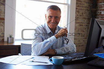 Portrait Of Mature Businessman Working In Office