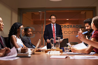 Smiling businessman addressing team at meeting, low angle