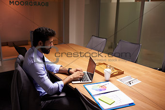 Hispanic businessman working late in office, elevated view