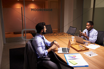 Two middle aged businessman working late in an office