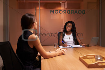 Two corporate businesswomen at an evening meeting in office