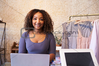 Mixed race sales assistant at the counter of clothing store