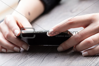 Woman typing in a text message on her smartphone