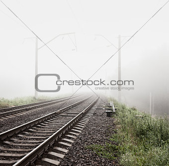 Railway in Fog. Misty Morning Landscape.