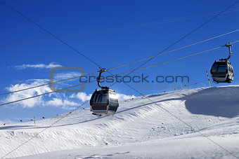 Gondola lifts on ski resort at sun wind day