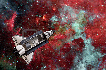 Space Shuttle over galaxy and space nebula.