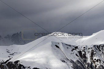 Sunlight mountains with snow cornice and trace from avalanche be