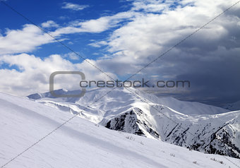Ski slope in evening and storm clouds