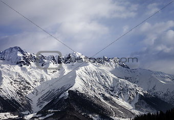 Snow winter mountain and gray sky in evening