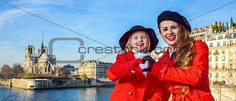 stylish mother and daughter in Paris showing heart shaped hands