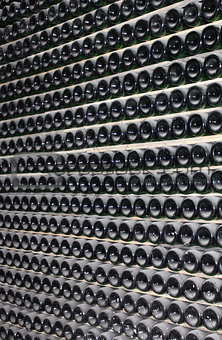 large stack of wine bottles in winery
