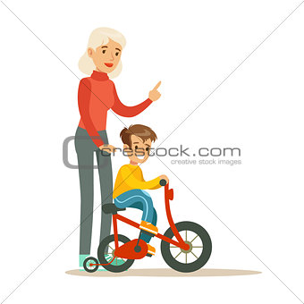 Grandmother Teaching Boy To Ride Bicycle, Part Of Grandparents Having Fun With Grandchildren Series