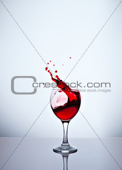 A glass with red wine and sprays.
