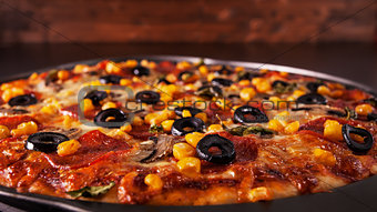 Freshly baked pizza in baking pan - closeup